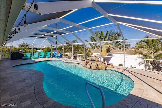 view of pool featuring glass enclosure and a patio area