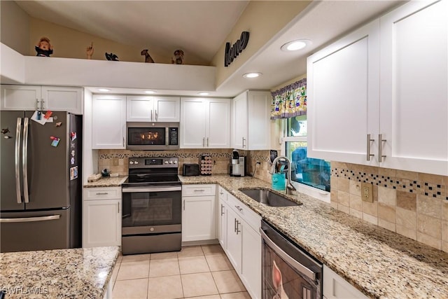 kitchen with lofted ceiling, white cabinetry, sink, and appliances with stainless steel finishes