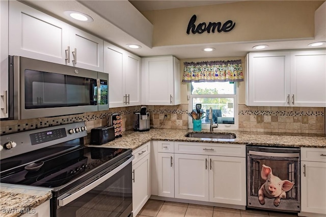 kitchen featuring light stone counters, white cabinetry, and appliances with stainless steel finishes