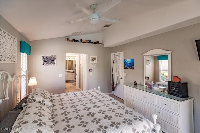 bedroom with ceiling fan, light tile patterned flooring, ensuite bathroom, and lofted ceiling