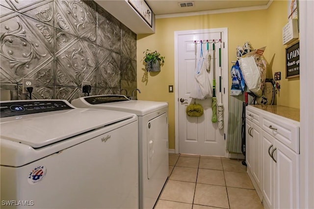 washroom featuring light tile patterned flooring, crown molding, cabinets, and washing machine and clothes dryer