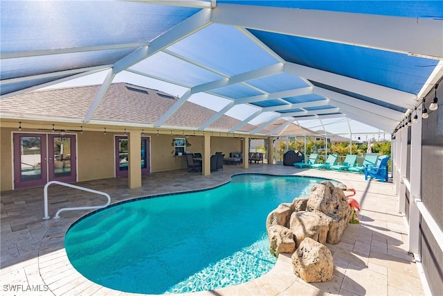 view of swimming pool with glass enclosure, ceiling fan, and a patio area