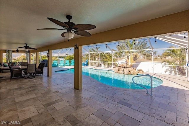 view of pool with glass enclosure, ceiling fan, and a patio