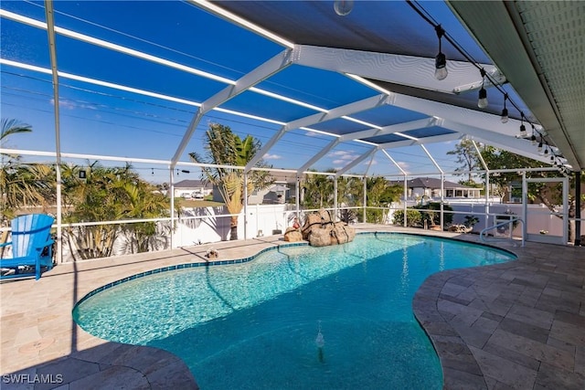 view of pool with glass enclosure and a patio area