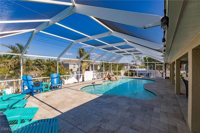 view of pool featuring glass enclosure and a patio