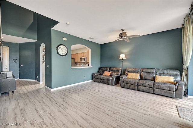 living room featuring ceiling fan and light hardwood / wood-style floors