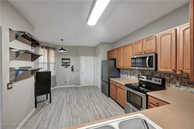 kitchen with decorative light fixtures, stainless steel appliances, tasteful backsplash, and light hardwood / wood-style floors