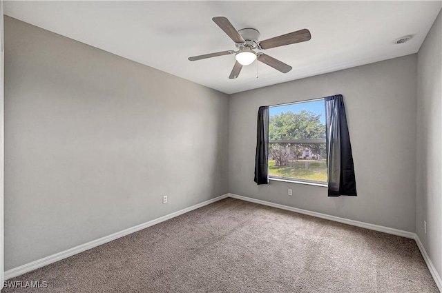 empty room featuring ceiling fan and carpet