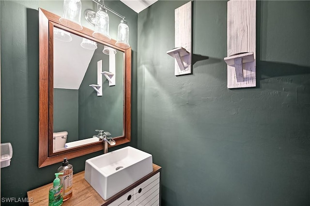 bathroom with hardwood / wood-style floors, vanity, and toilet