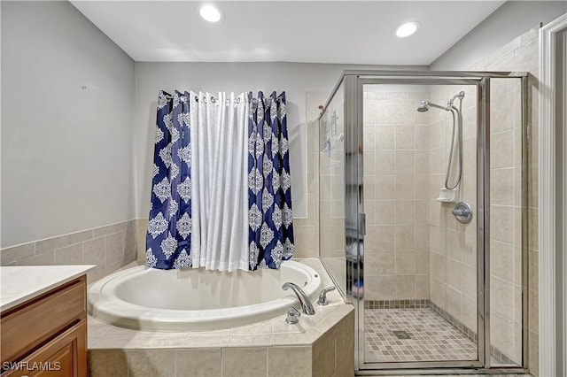 bathroom featuring vanity and independent shower and bath