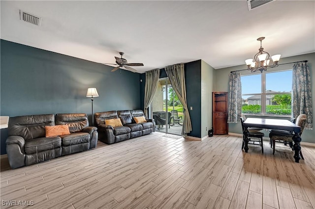 living room featuring ceiling fan with notable chandelier, light hardwood / wood-style floors, and a healthy amount of sunlight