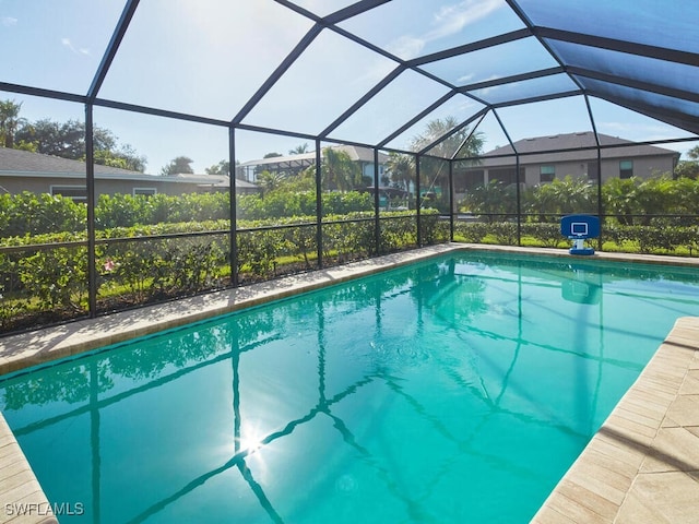 view of swimming pool featuring glass enclosure