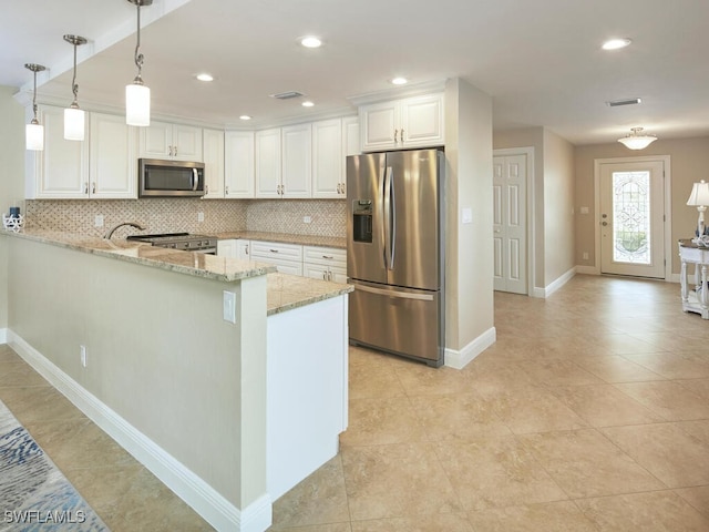 kitchen with pendant lighting, white cabinets, appliances with stainless steel finishes, light stone counters, and kitchen peninsula