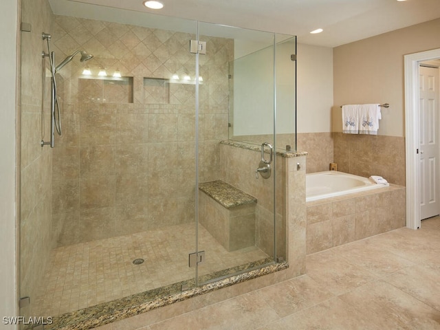 bathroom with tile patterned flooring and separate shower and tub