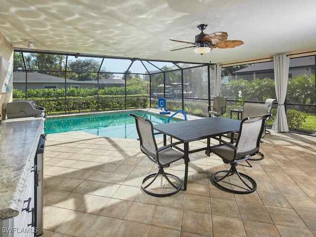 view of swimming pool featuring glass enclosure, ceiling fan, and a patio