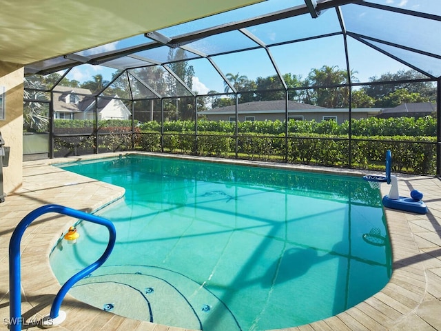 view of swimming pool with glass enclosure and a patio area