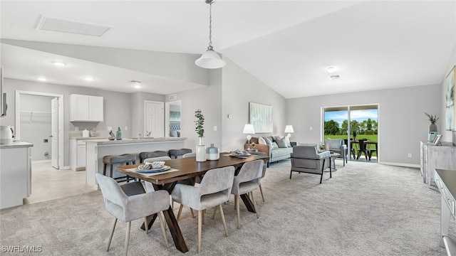 dining area featuring light carpet and high vaulted ceiling