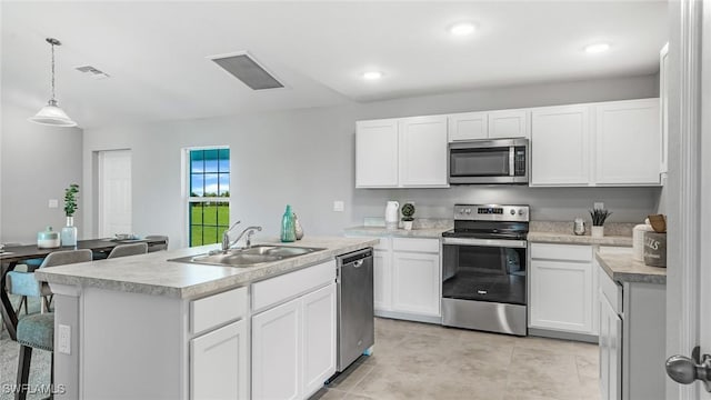 kitchen with appliances with stainless steel finishes, white cabinetry, and sink