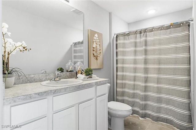 bathroom featuring tile patterned flooring, vanity, and toilet