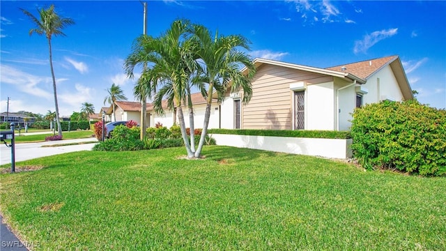 view of side of property featuring a garage and a lawn