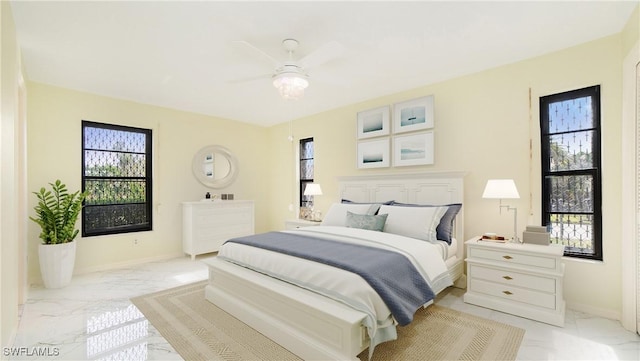 bedroom featuring multiple windows and ceiling fan