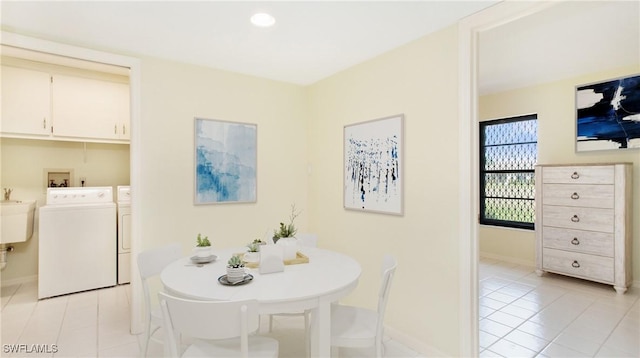 tiled dining space featuring washer and clothes dryer and sink