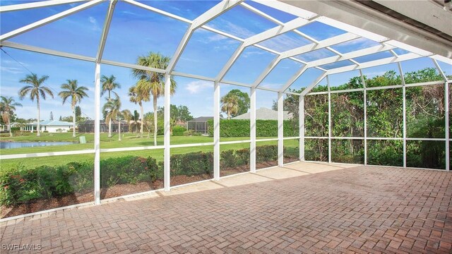 unfurnished sunroom with a swimming pool, a water view, and vaulted ceiling