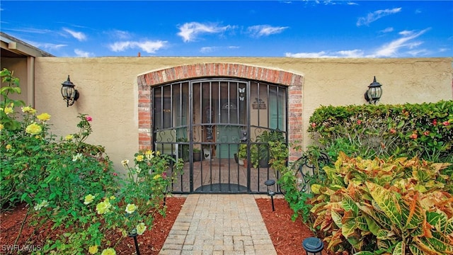 entrance to property with a gate and stucco siding