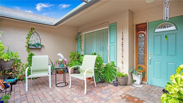 entrance to property featuring a patio and stucco siding