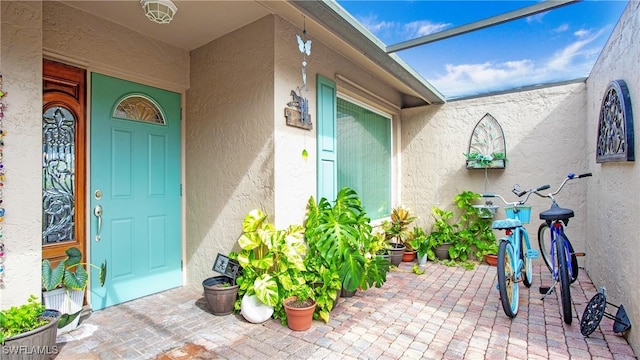 property entrance featuring a patio and stucco siding