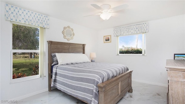 bedroom with ceiling fan and multiple windows