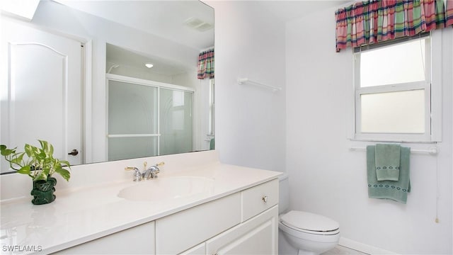 bathroom featuring vanity, toilet, and a shower with door