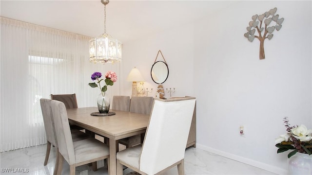 dining room with a chandelier, marble finish floor, and baseboards