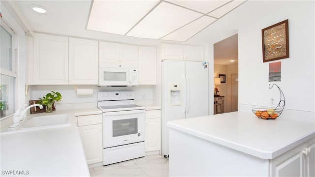 kitchen with white cabinets, white appliances, and sink