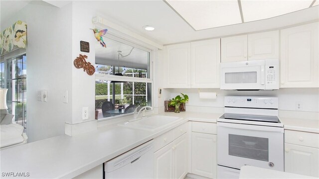 kitchen featuring white cabinets, white appliances, and sink