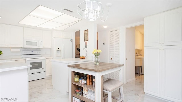 kitchen with white appliances, white cabinetry, marble finish floor, light countertops, and an inviting chandelier