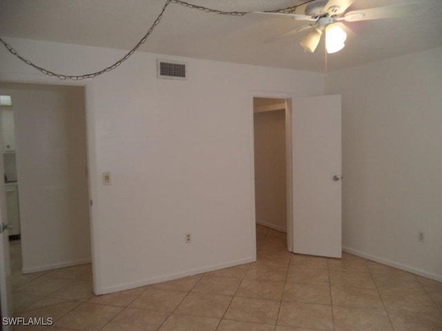 tiled empty room with ceiling fan