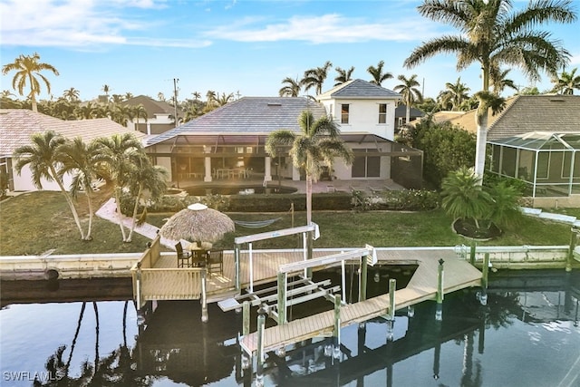 dock area featuring a lanai, a water view, and a lawn