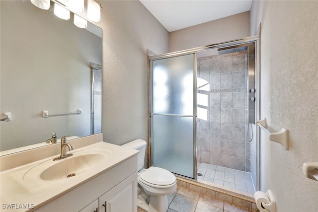 bathroom with a shower with shower door, vanity, tile patterned flooring, and toilet