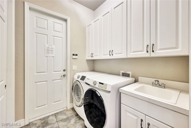 clothes washing area featuring cabinets, sink, washer and clothes dryer, and light tile patterned flooring