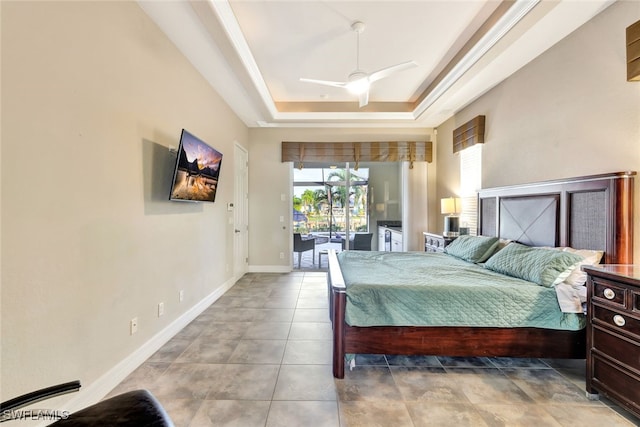 bedroom with ceiling fan, access to exterior, and a raised ceiling