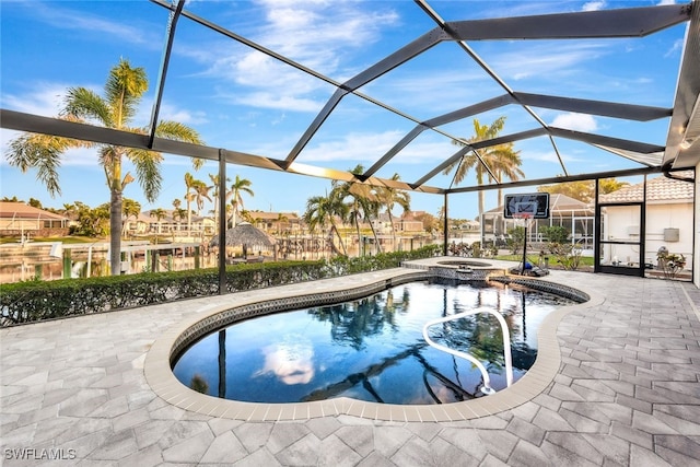 view of swimming pool with glass enclosure, a patio area, and an in ground hot tub