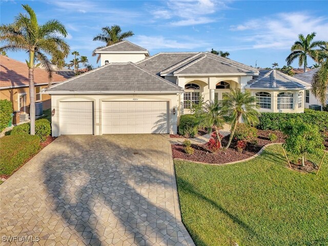 ranch-style house with a garage, a front yard, and central air condition unit