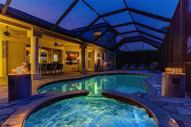 view of pool featuring ceiling fan, glass enclosure, an in ground hot tub, and a patio