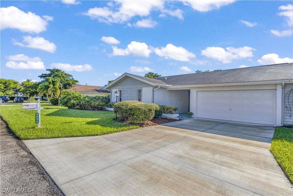 single story home featuring a garage and a front lawn