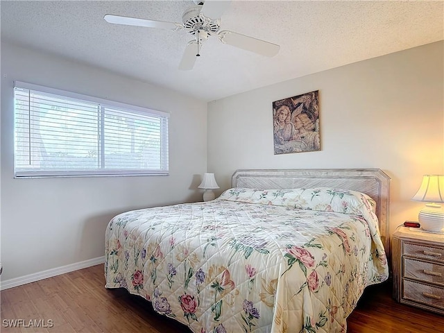 bedroom with ceiling fan, a textured ceiling, baseboards, and wood finished floors