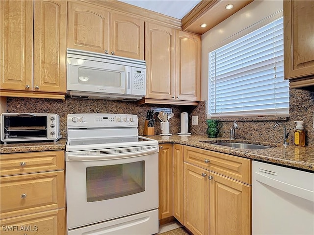 kitchen featuring backsplash, light stone countertops, white appliances, and sink