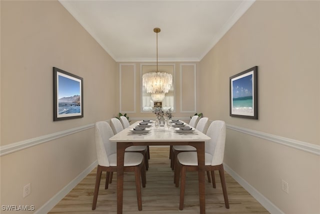 dining space featuring a notable chandelier, ornamental molding, and light hardwood / wood-style flooring