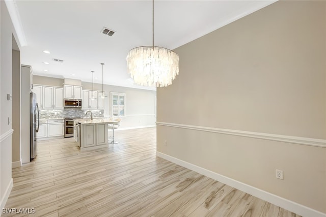 unfurnished dining area with light hardwood / wood-style floors, sink, and a chandelier