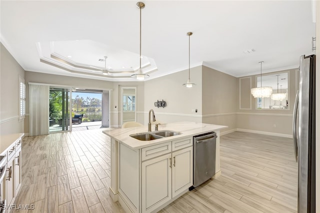 kitchen featuring hanging light fixtures, a kitchen island with sink, sink, and stainless steel appliances